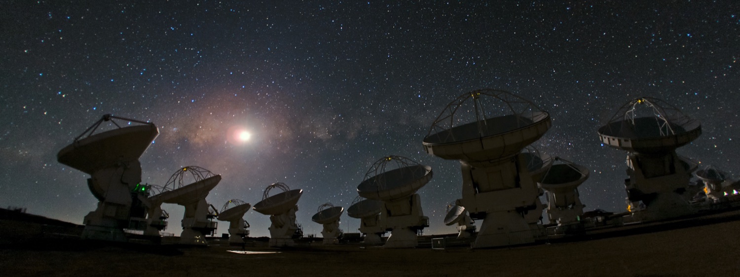 ALMA radio antennas on the Chajnantor plateau at night under the arc of the Milky Way