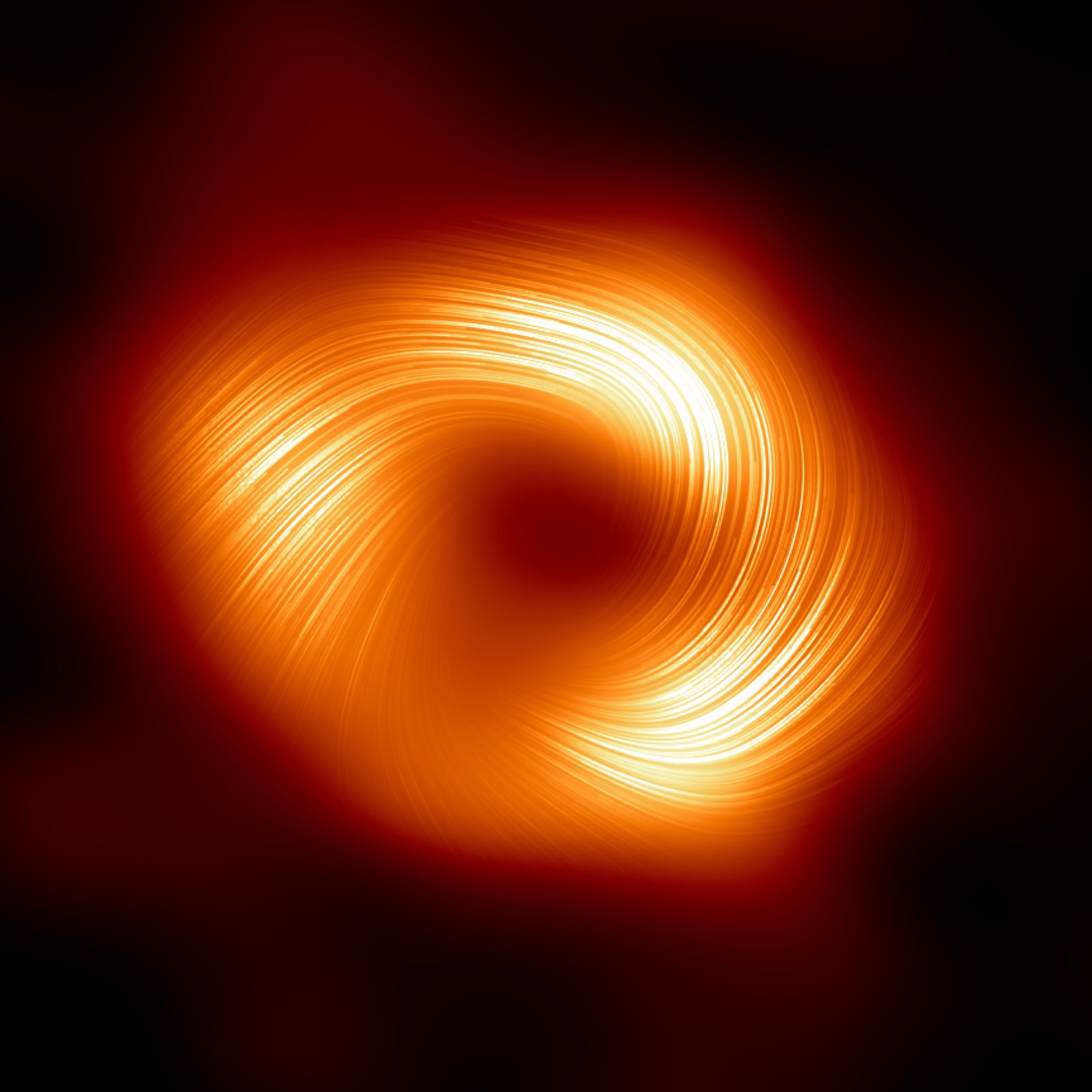 Sagittarius A* imaged in polarised light, showing spiralling magnetic field lines threaded through the glowing ring