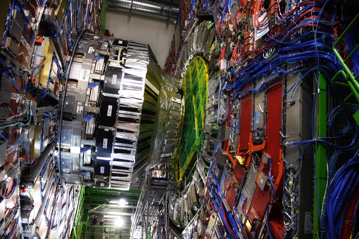 The CMS detector at CERN's Large Hadron Collider: a huge cylindrical machine of layered red, blue and silver electronics and cabling around a central beam pipe